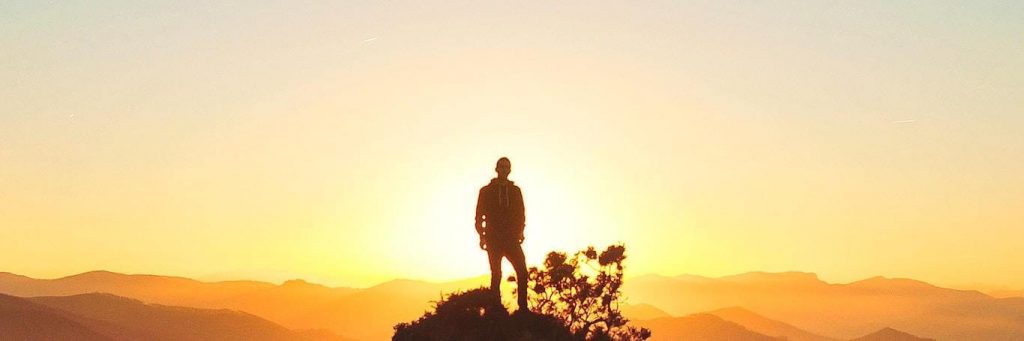 man stands on rock beautiful sunset scene