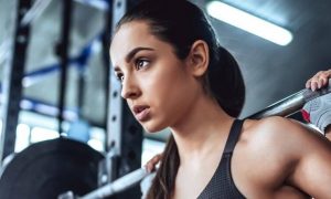 woman carries barbell working out exercising in gym