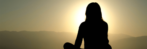 woman shadow sits leg crossed concentrates on meditation in sunny sky