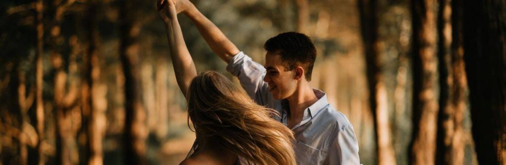couple happily dances in forest in sunny sky
