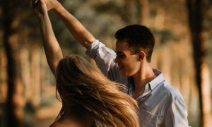 couple happily dances in forest in sunny sky
