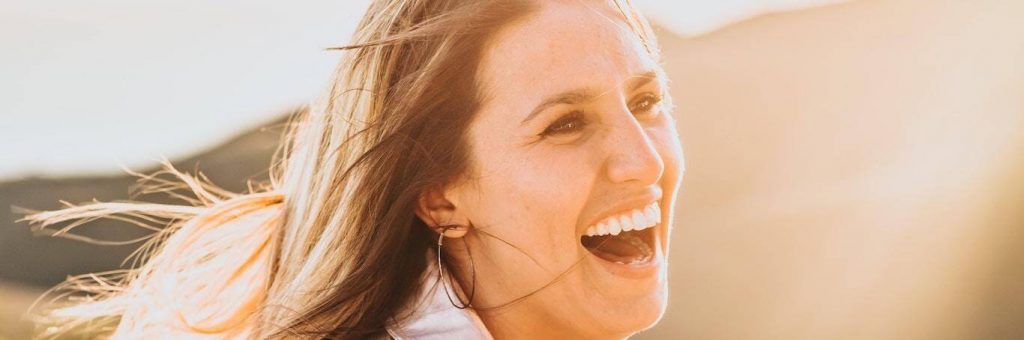 woman excited happy laughing in sunny sky