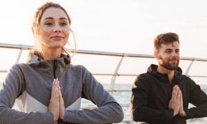 couple sits on bridge practices meditation