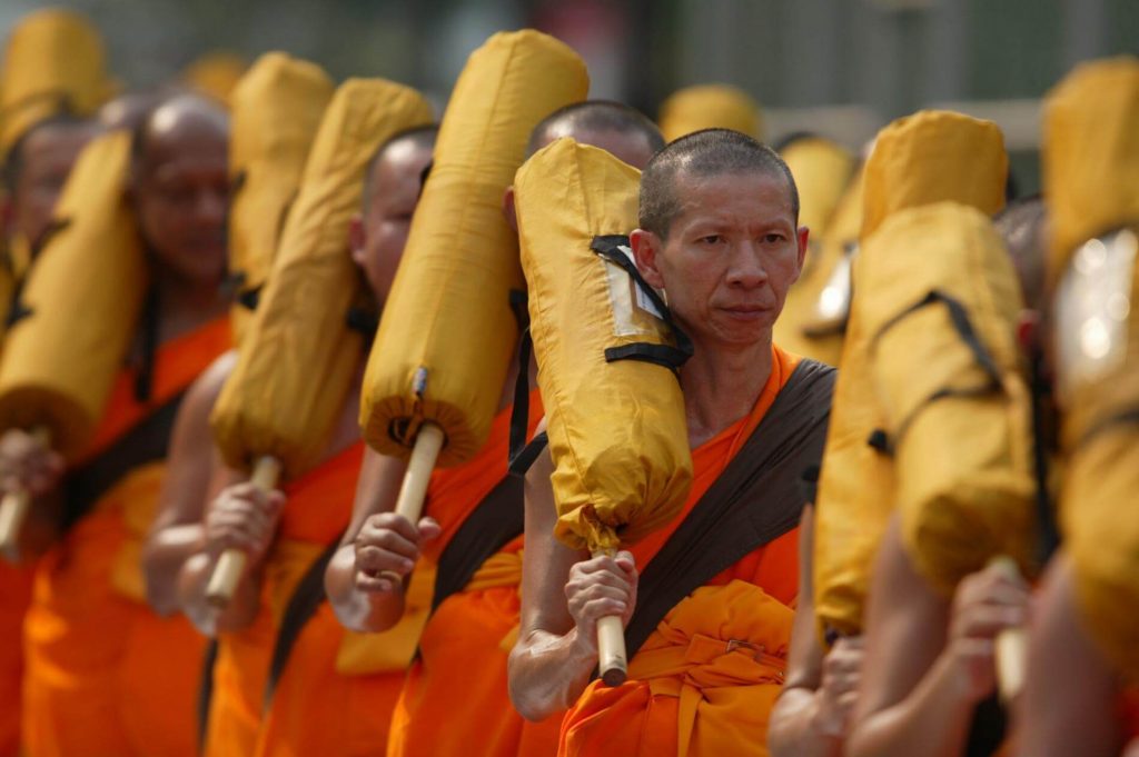 people wearing orange clothes holding yellow sticks