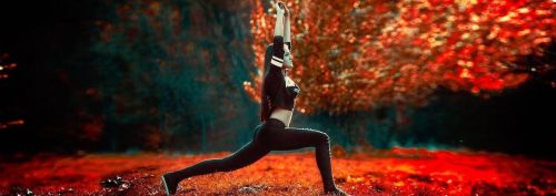 young woman stands in red leaves forest stretching practicing yoga
