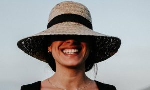 woman wearing white hat happily smiling