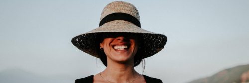 woman wearing white hat happily smiling