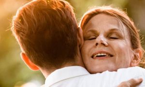 old woman satisfied hugging son