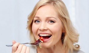 woman using fork eating smiling