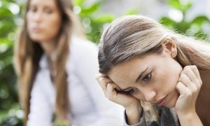 woman sits feeling sad hurt while lady looking at her