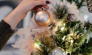 hand decorates christmas tree