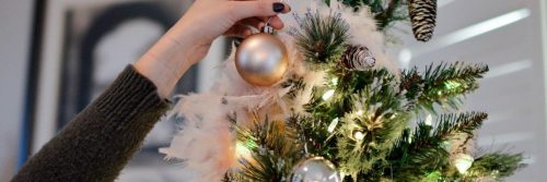 hand decorates christmas tree