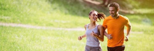 couple happily exercises jogging in park in sunny sky