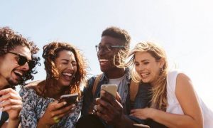 group of friends happily talk laugh discuss about topics on mobile phones