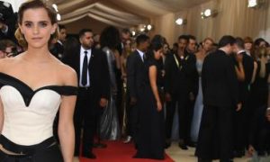 woman wearing dress poses for photos beside crowd paparazzi celebrity