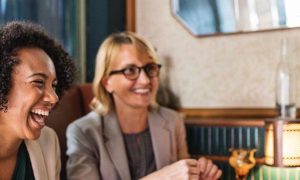 three women sit on luxury restaurant talking laughing