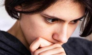 woman hand on face seriously thinking feeling confused