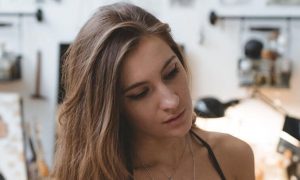 woman sits in painting room focuses on drawing