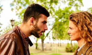 couple argues in forest man trying to explain while woman angrily listening looking at him