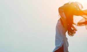 woman stands gratitude life in sunny sky