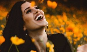 woman stands in beautiful garden happily laughing blissing
