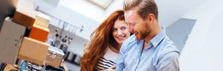 couple stands in kitchen happily laughing