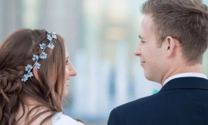 married couple stands looking at each other smiling