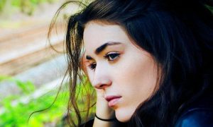 woman sadly wistful eyes sitting worrying about life