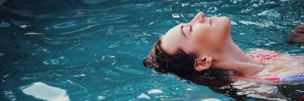 woman swimming backstroke relaxing in pool