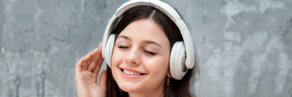 young woman wearing headphone enjoying listening to music