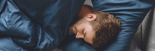 man sleeps tight on bed